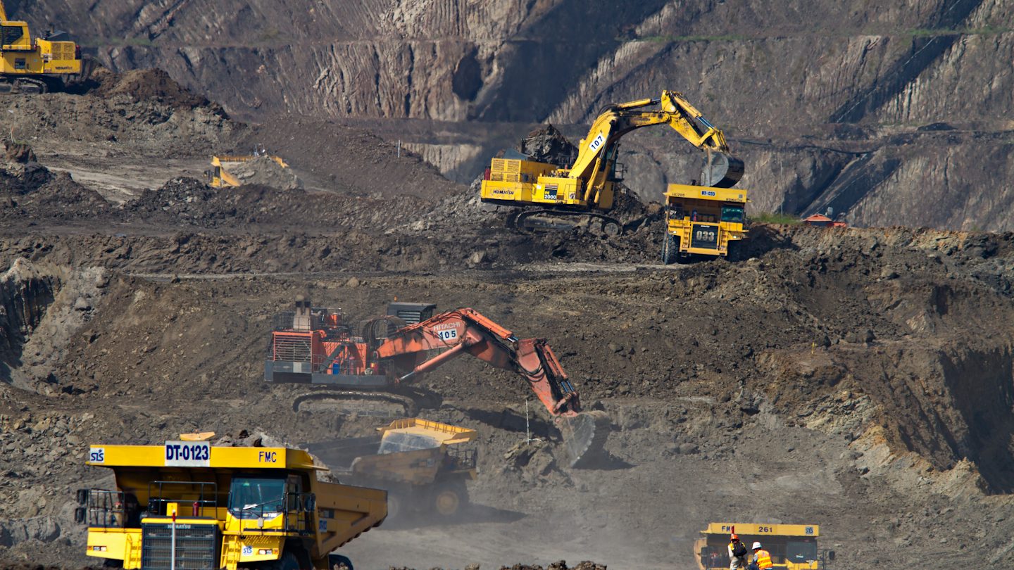Excavatrices et camions-bennes dans une mine à ciel ouvert