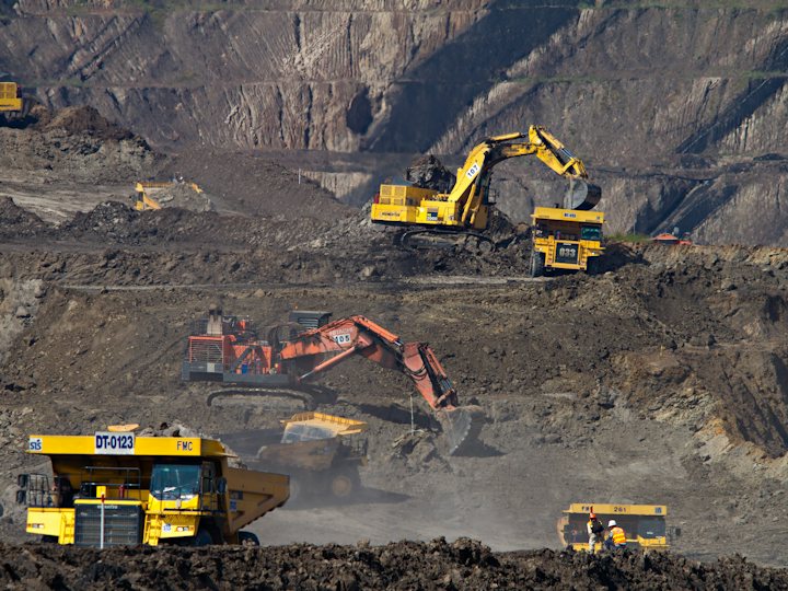 Excavatrices et camions-bennes dans une mine à ciel ouvert